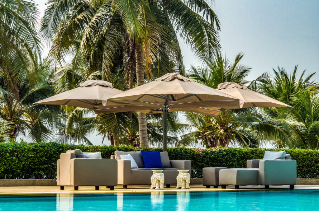 Outdoor Furniture with Umbrellas Cushions and Pillows by the Pool